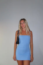Load image into Gallery viewer, Woman wearing a blue dress against a plain background
