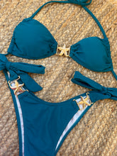 Load image into Gallery viewer, A blue halter bikini set with seashell-inspired design, displayed on a textured background.