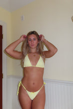 Load image into Gallery viewer, Woman in a yellow bikini posing indoors against a neutral wall.