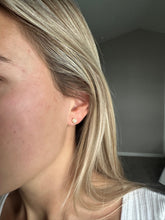 Load image into Gallery viewer, Close-up of a person wearing a gold earring with a plain background