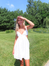 Load image into Gallery viewer, Woman in a white dress standing on grass with trees and blue sky in the background