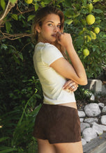 Load image into Gallery viewer, Woman in a white top and brown shorts standing in front of a lemon tree