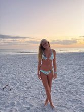 Load image into Gallery viewer, Woman in a bikini standing on a beach at sunset