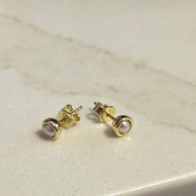 Load image into Gallery viewer, Gold stud earrings with a clear gemstone on a light marble surface