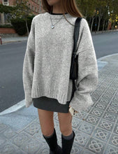 Load image into Gallery viewer, Person wearing a gray sweater and black skirt on a street.