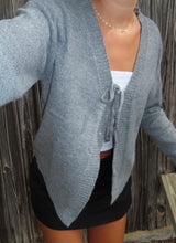 Load image into Gallery viewer, Person wearing a gray cardigan over a white top and black skirt against a wooden fence background