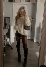 Load image into Gallery viewer, Person wearing a white cable knit sweater, black shorts, and knee-high boots in a room.