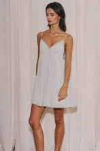 Load image into Gallery viewer, Light sage green babydoll mini dress with adjustable spaghetti straps, lace trim, side tie details, and a flowy tiered skirt for summer.