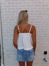 Load image into Gallery viewer, Person wearing a white top and blue shorts on a textured floor.
