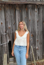 Load image into Gallery viewer, Woman standing on a wooden floor wearing a white top and blue jeans.