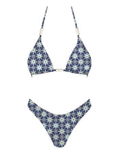 Load image into Gallery viewer, A bikini set with a kaleidoscopic floral print in deep navy and icy white tones, featuring a triangle top detailed with pearl-like beads along the straps and center.