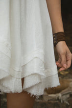 Load image into Gallery viewer, Close-up of a white textured dress with a blurred natural background