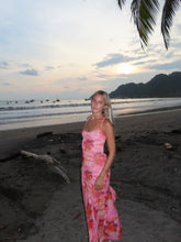 Load image into Gallery viewer, Woman in a pink dress standing on a beach with palm trees in the background