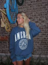 Load image into Gallery viewer, Person wearing a blue sweatshirt with 'United States Army' logo on a patterned wall background