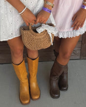 Load image into Gallery viewer, Two people standing outdoors wearing white and light pink eyelet dresses, with one holding a woven straw handbag and the other wearing tan and one wearing dark brown boots.
