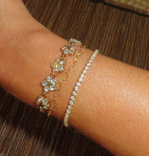 Load image into Gallery viewer, A gold-plated bracelet with clear gemstone accents, featuring an adjustable clasp, displayed on a wrist.