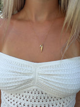 Load image into Gallery viewer, A close-up of a model wearing a delicate gold necklace with a small seahorse pendant, paired with a white knit off-the-shoulder top.