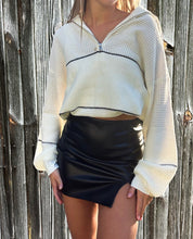 Load image into Gallery viewer, A person wearing a beige and black striped quarter zip sweater with long sleeves, paired with a black leather skirt.