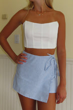 Load image into Gallery viewer, Woman wearing a white strapless top and blue and white striped skirt against a neutral background