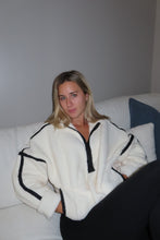 Load image into Gallery viewer, Woman wearing a white coat with black trim in a minimal indoor setting