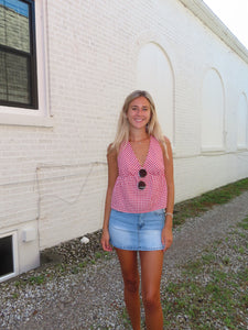 Woman standing in front of a white building with a gravel area.