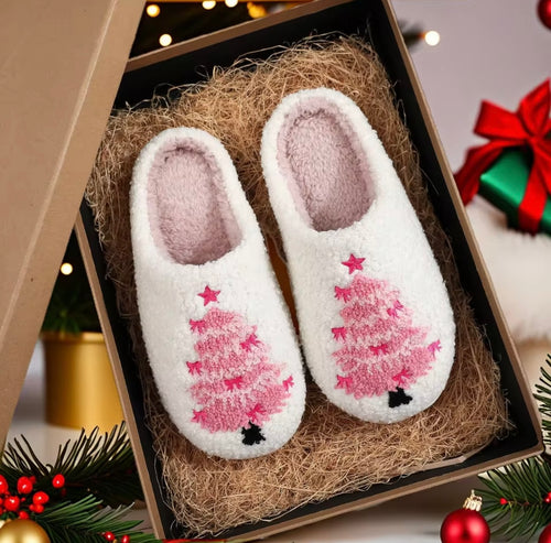 Pair of white slippers with pink tree design in a decorative box with Christmas decorations.
