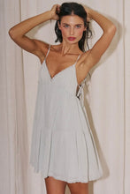 Load image into Gallery viewer, Light sage green babydoll mini dress with adjustable spaghetti straps, lace trim, side tie details, and a flowy tiered skirt for summer.
