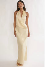 Load image into Gallery viewer, Butter yellow satin halter maxi dress with draped surplice neckline, open tie-back design, and elegant floor-length silhouette for weddings and formal events.
