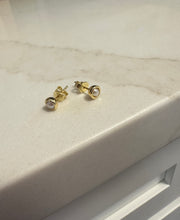 Load image into Gallery viewer, Gold stud earrings on a light marble surface
