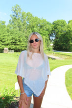 Load image into Gallery viewer, Model wearing a white lightweight knit beach cover-up over a bikini with denim shorts outdoors on a sunny summer day
