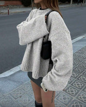 Load image into Gallery viewer, Person wearing a light gray oversized sweater on a street.
