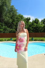 Load image into Gallery viewer, Woman in a floral dress standing by a pool with trees in the background
