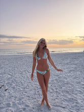 Load image into Gallery viewer, Woman in a bikini standing on a beach at sunset
