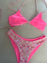 Load image into Gallery viewer, Pink bikini set with floral patterned sides on a textured surface
