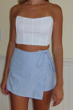 Load image into Gallery viewer, White strapless top and blue striped skirt worn by a person against a neutral background
