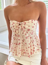 Load image into Gallery viewer, A strapless beige crop top with a knitted twist detail and a floral design towards the bottom.
