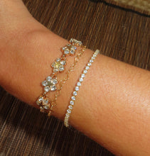 Load image into Gallery viewer, A gold-plated bracelet with clear gemstone accents, featuring an adjustable clasp, displayed on a wrist.
