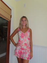 Load image into Gallery viewer, A woman standing in a doorway, wearing a vibrant yellow floral A-line mini ruffle dress with three-quarter sleeves and a mini skirt.
