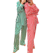 Load image into Gallery viewer, Two individuals modeling red and green striped satin pajamas, consisting of a button-up long-sleeve top and pants with an elastic waistband.
