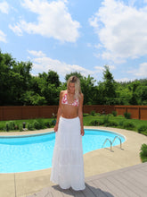 Load image into Gallery viewer, Woman standing by a pool with a blue sky and clouds in the background
